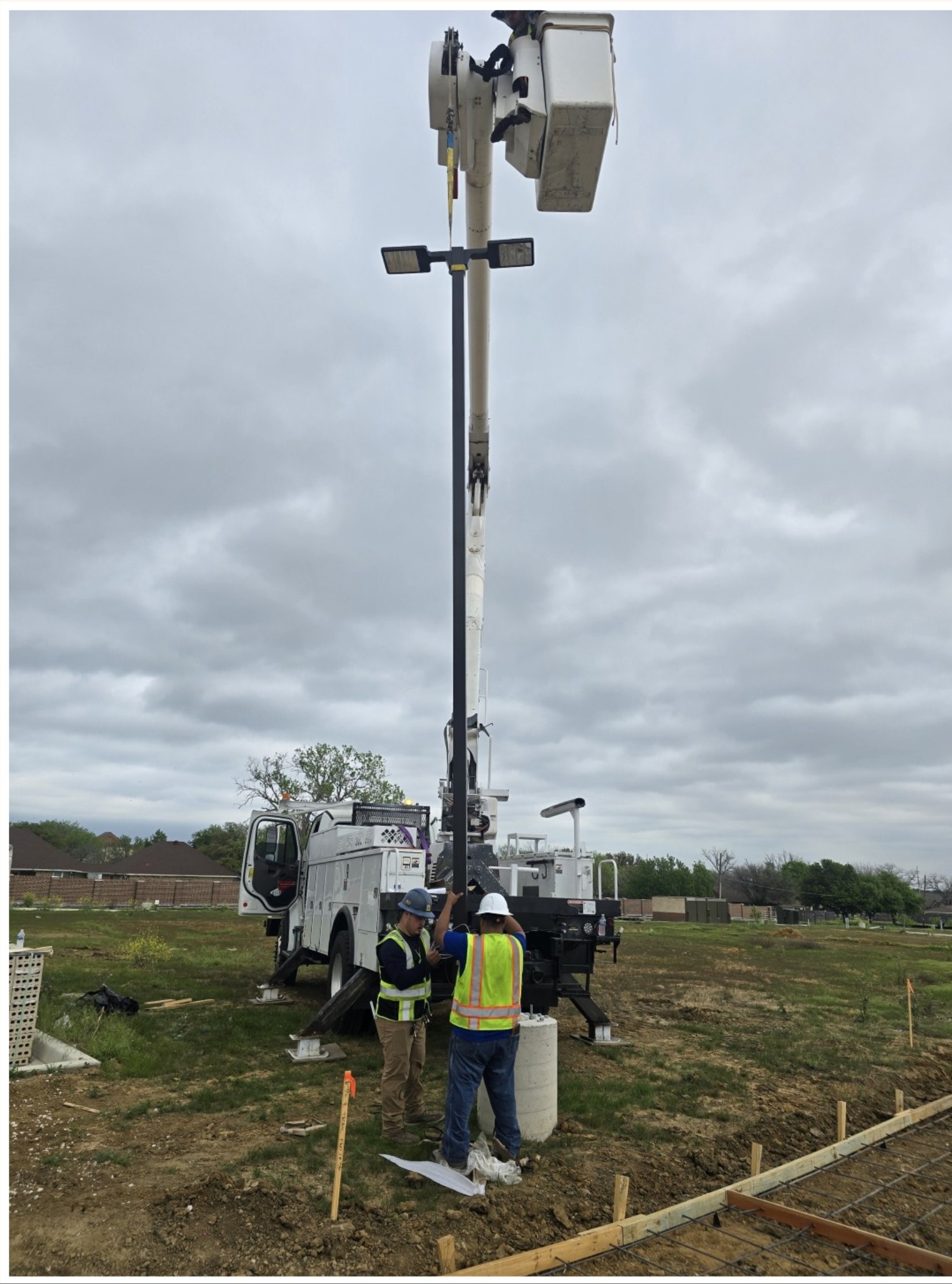 Lumen crew installing a new LED pole light with a bucket truck
